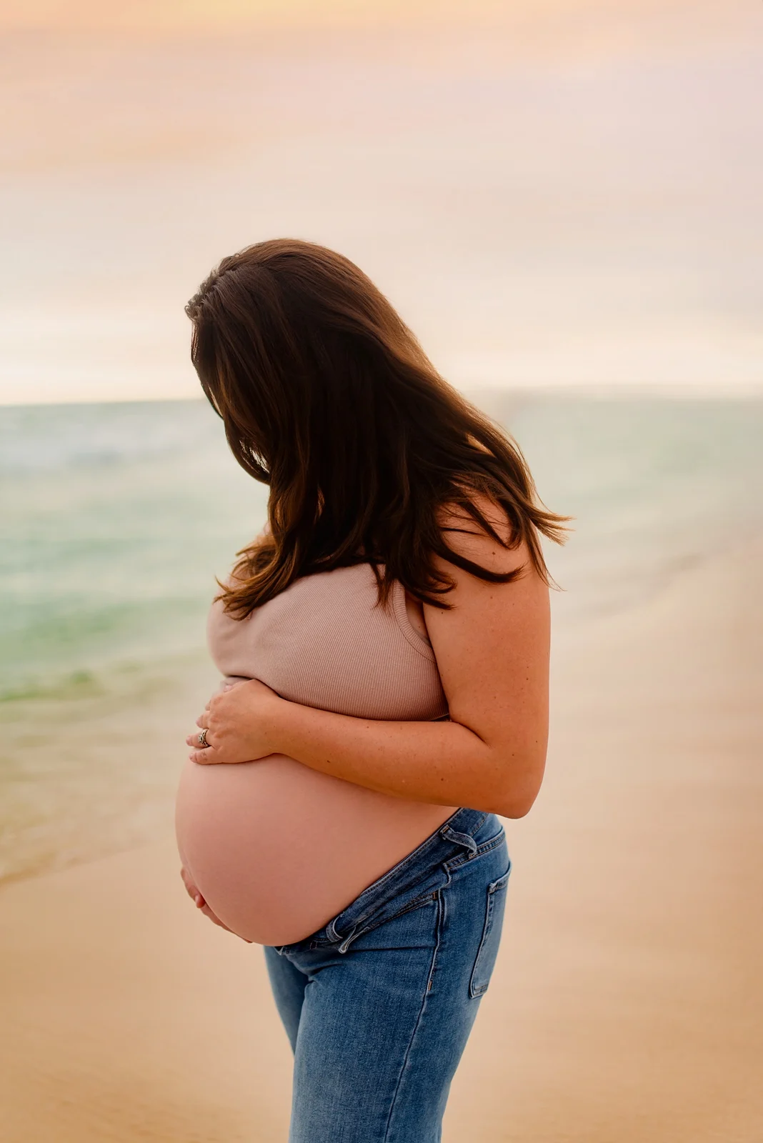 Maternity portrait on Pensacola Beach in pastel sunset light