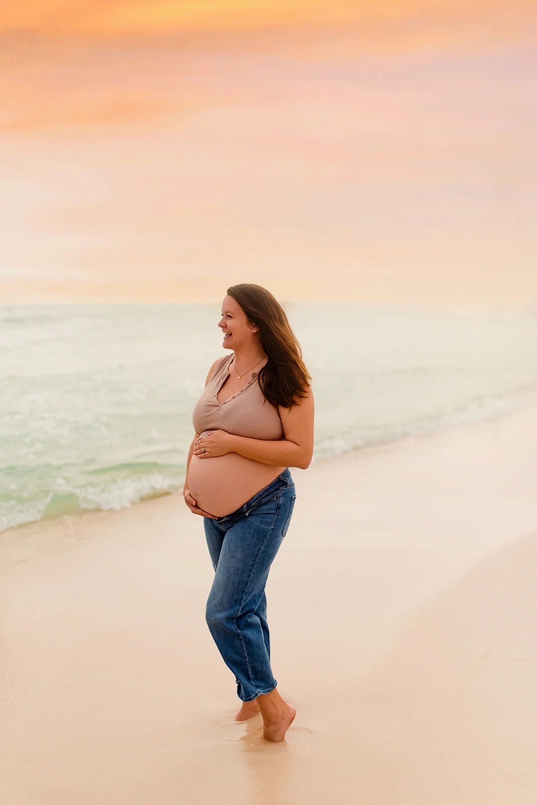 Expecting mother standing on Pensacola Beach at sunset