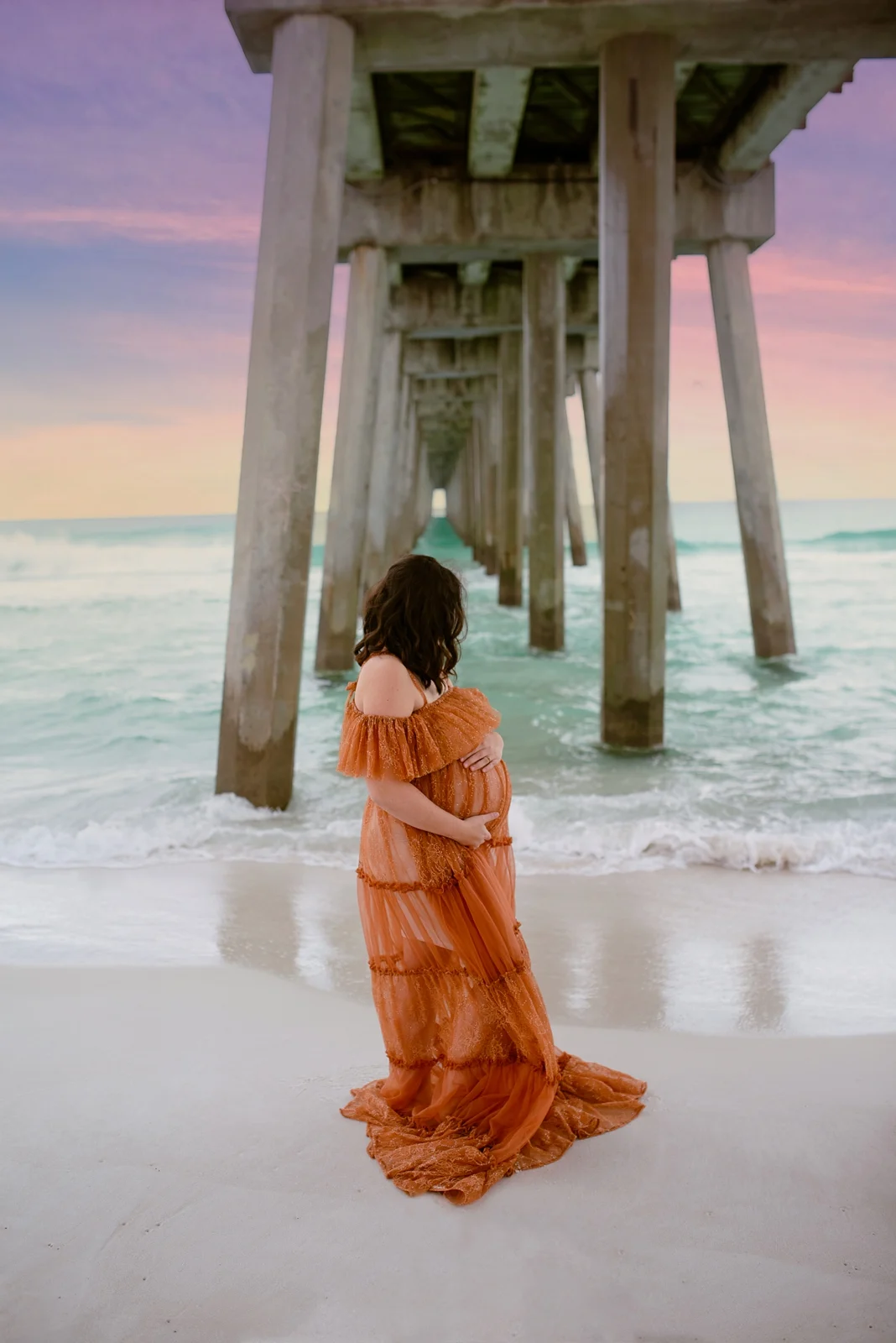 Expecting mother in a rust dress on the Gulf Coast