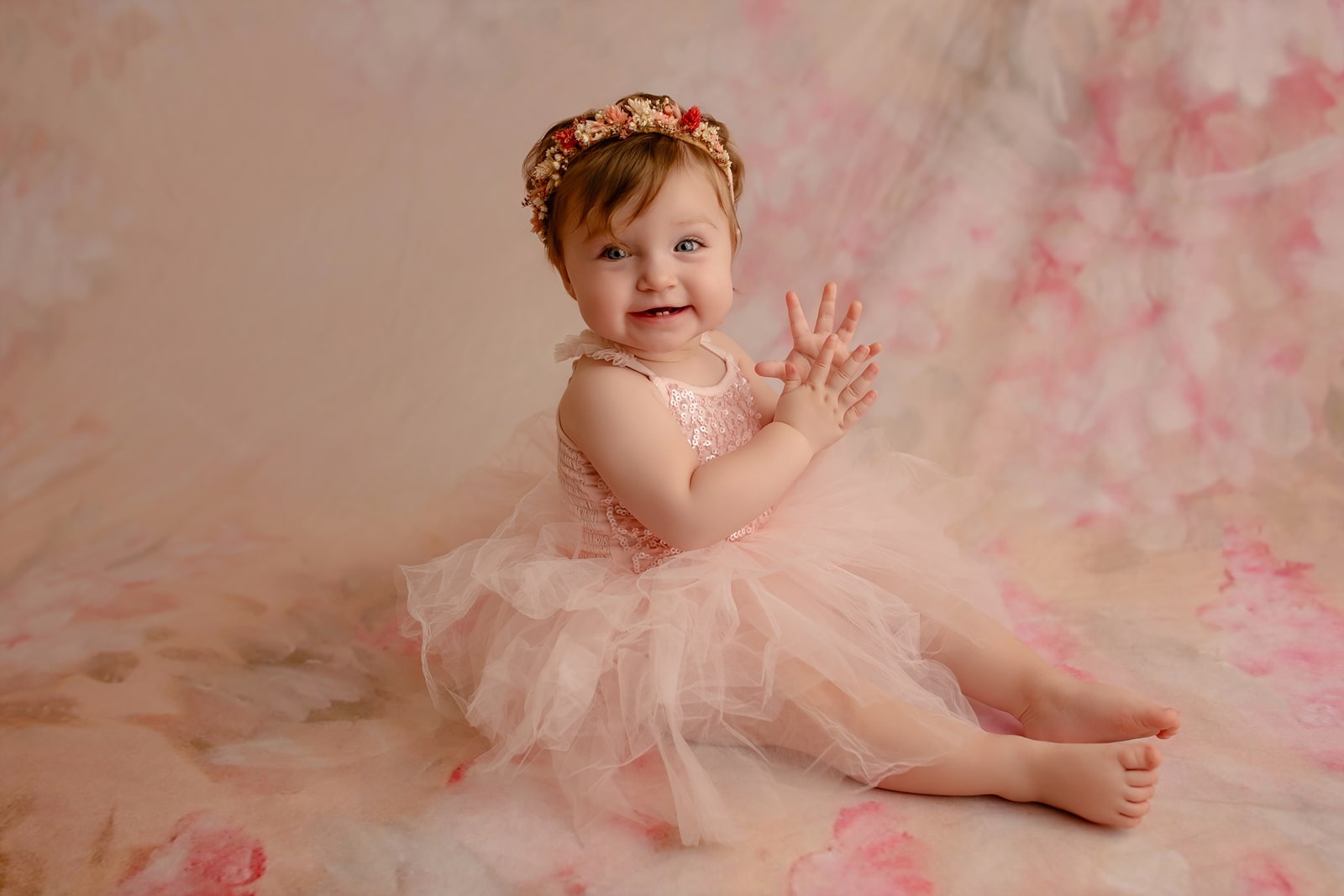 Baby in a floral crown and pink tutu, clapping