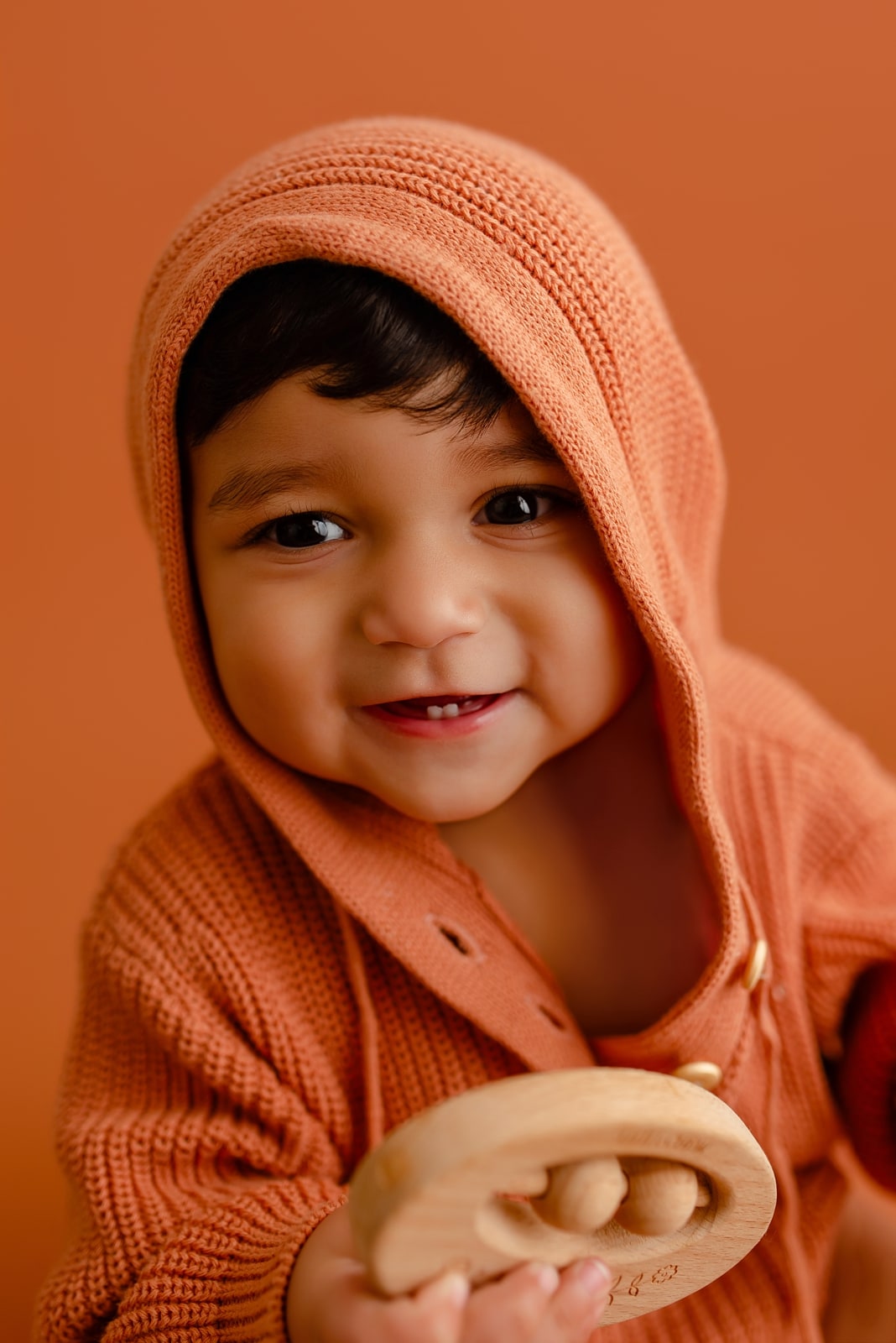 Baby in an orange hoodie milestone portrait