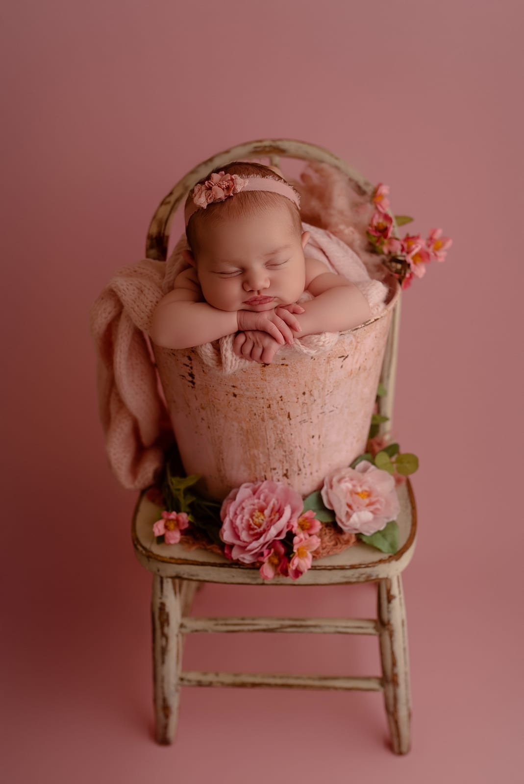 Newborn in pink chair setup